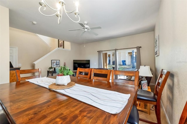 dining room featuring stairway, ceiling fan with notable chandelier, baseboards, and wood finished floors
