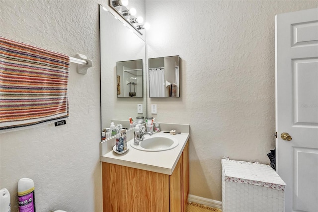 bathroom with vanity and a textured wall