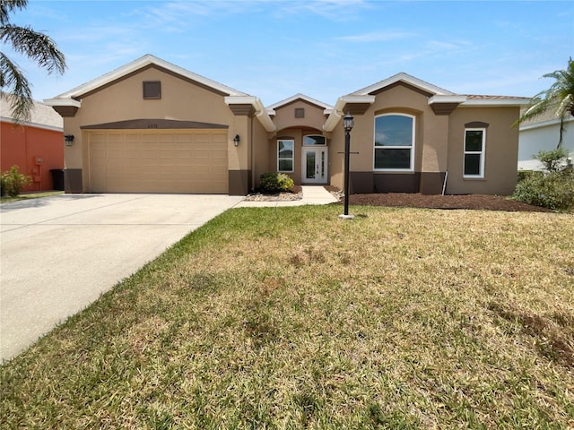 view of front facade featuring stucco siding, french doors, an attached garage, concrete driveway, and a front yard