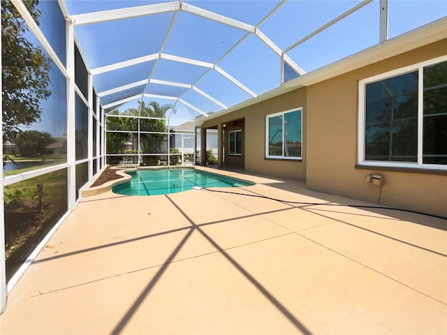 swimming pool featuring a patio and glass enclosure