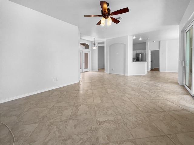 unfurnished living room with ceiling fan and baseboards
