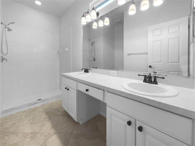 full bathroom featuring a tile shower, double vanity, and tile patterned flooring