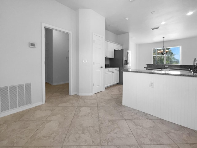 kitchen featuring a chandelier, white cabinetry, stainless steel fridge with ice dispenser, decorative light fixtures, and light tile patterned floors