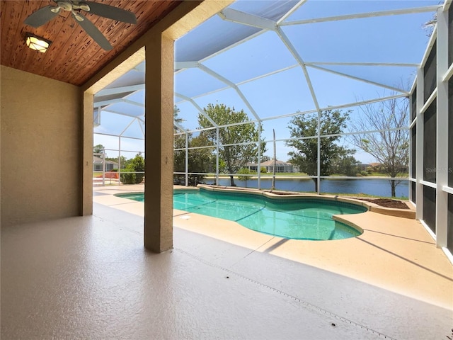 outdoor pool with a patio area, a ceiling fan, and glass enclosure