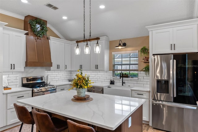 kitchen with a sink, a kitchen bar, custom range hood, stainless steel appliances, and tasteful backsplash