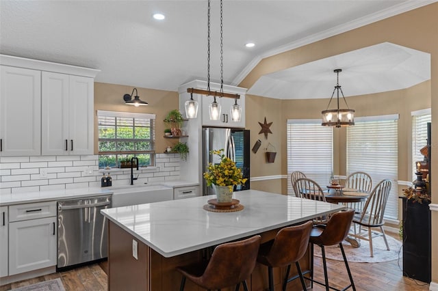 kitchen with decorative backsplash, stainless steel appliances, wood finished floors, and a sink