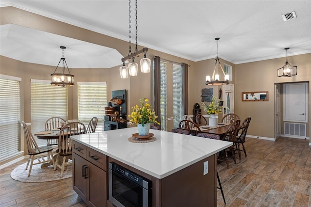kitchen with dark wood-style flooring, built in microwave, baseboards, and a notable chandelier