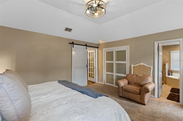 bedroom featuring ensuite bathroom, carpet flooring, a barn door, and visible vents