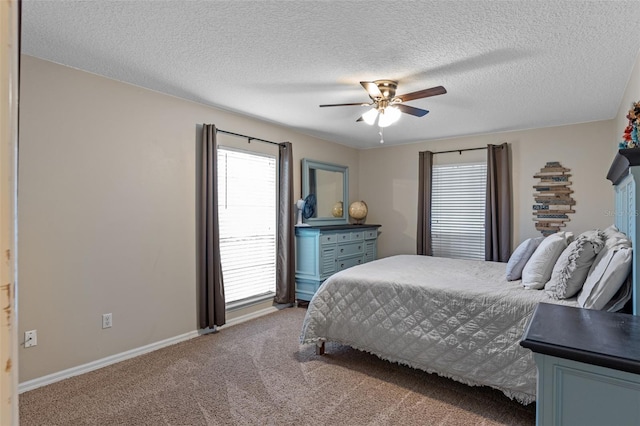 carpeted bedroom with a textured ceiling, baseboards, and a ceiling fan