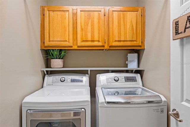 washroom featuring separate washer and dryer and cabinet space