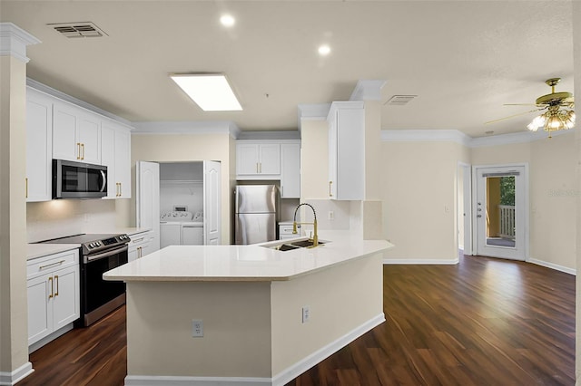 kitchen featuring a sink, a peninsula, dark wood finished floors, separate washer and dryer, and appliances with stainless steel finishes