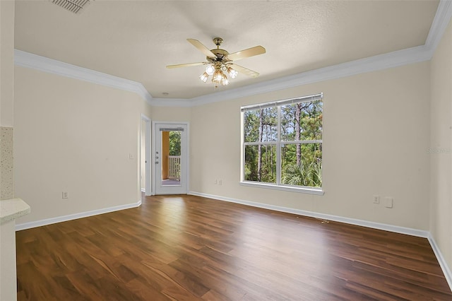 empty room featuring a ceiling fan, crown molding, visible vents, baseboards, and dark wood-style flooring