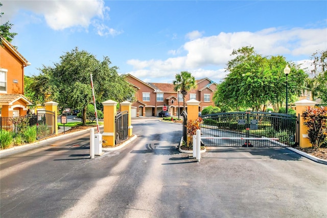 view of street with street lighting, curbs, traffic signs, a gated entry, and a gate