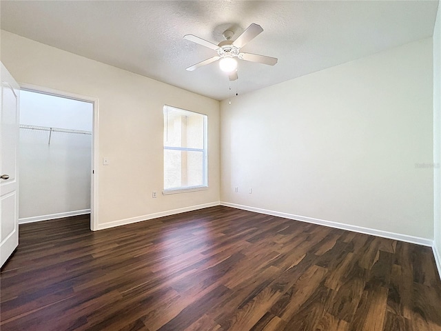 unfurnished bedroom featuring a closet, dark wood finished floors, and baseboards