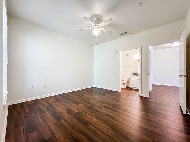 unfurnished bedroom featuring visible vents, ceiling fan, dark wood-style floors, connected bathroom, and baseboards