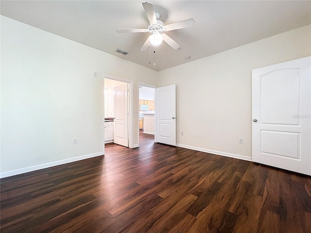 unfurnished bedroom with baseboards, dark wood-style flooring, ensuite bathroom, and visible vents