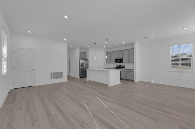 305 Platform Ln, Debary, FL 32713 - kitchen with light wood-style flooring, open floor plan, gray cabinets, and appliances with stainless steel finishes