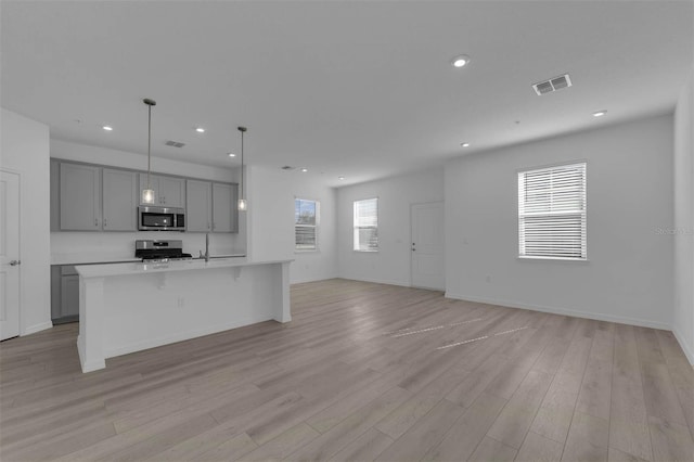 305 Platform Ln, Debary, FL 32713 - kitchen with appliances with stainless steel finishes, visible vents, open floor plan, light wood-type flooring, and gray cabinets