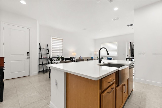 2524 Datura Loop, Saint Cloud, FL 34772 - kitchen featuring a sink, light tile patterned flooring, a center island with sink, brown cabinetry, and light countertops