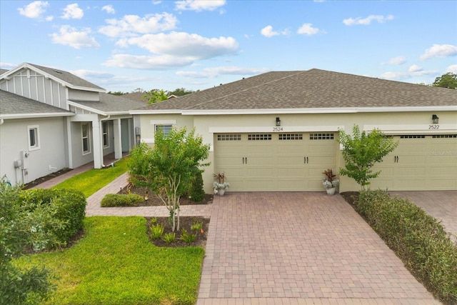 2524 Datura Loop, Saint Cloud, FL 34772 - ranch-style home featuring an attached garage, a shingled roof, decorative driveway, stucco siding, and a front lawn