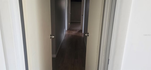 hall with baseboards and dark wood finished floors