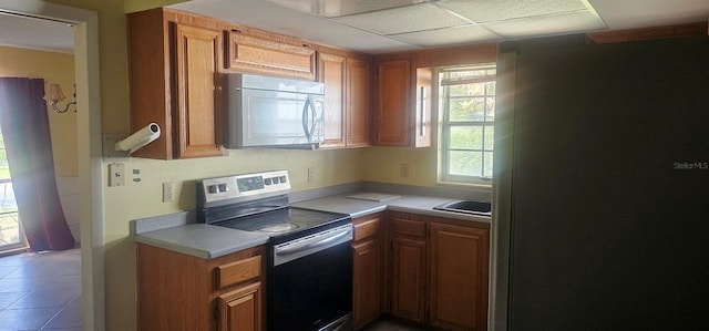 kitchen featuring light countertops, stainless steel appliances, and brown cabinetry