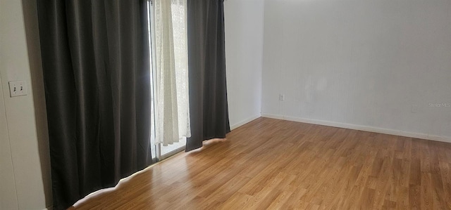 unfurnished room featuring baseboards and light wood-style flooring