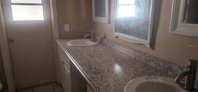 bathroom with a wealth of natural light, tile patterned floors, and vanity