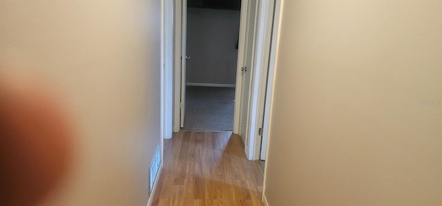 hallway featuring light wood-type flooring and visible vents