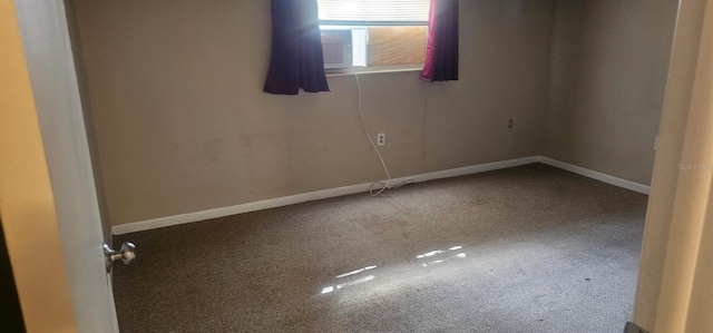 empty room featuring cooling unit, carpet floors, and baseboards