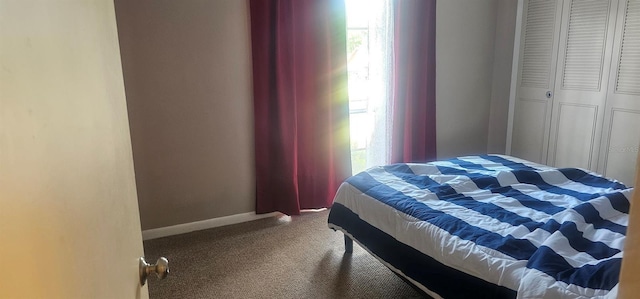 carpeted bedroom featuring baseboards and a closet