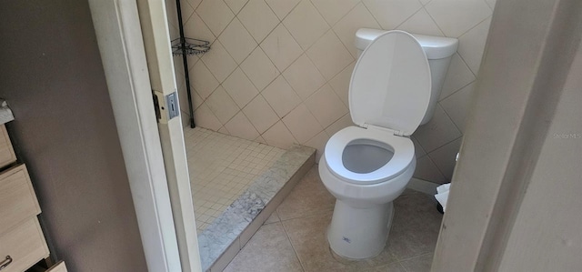 full bath with tile patterned floors, toilet, tile walls, and tiled shower