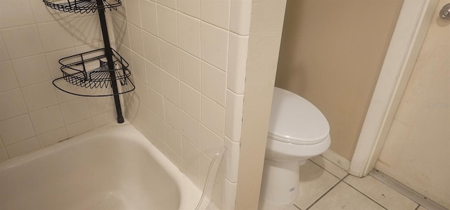 bathroom featuring tile patterned floors, toilet, and a bathing tub