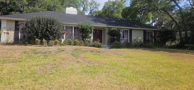 single story home with a front lawn, stucco siding, and a chimney