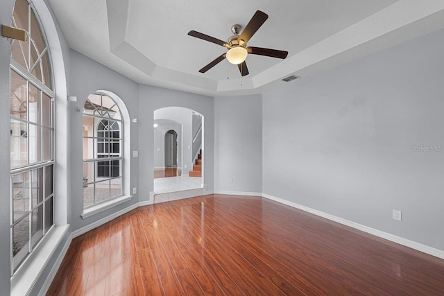 1802 Imperial Palm Dr, Apopka, FL 32712 - spare room with a raised ceiling, arched walkways, wood finished floors, a ceiling fan, and baseboards
