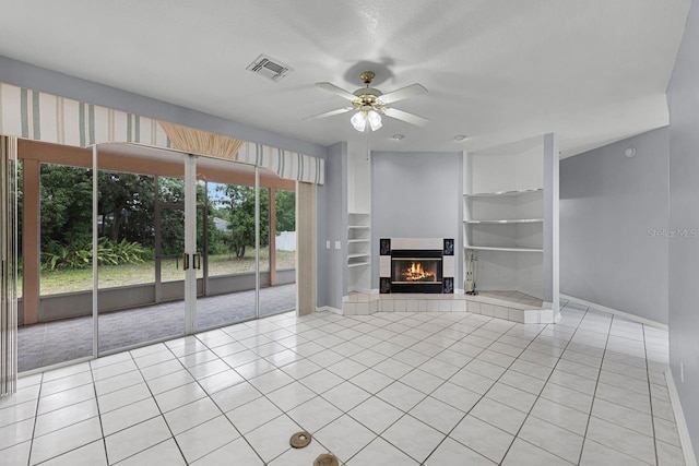 1802 Imperial Palm Dr, Apopka, FL 32712 - unfurnished living room with light tile patterned floors, built in features, a tile fireplace, ceiling fan, and baseboards