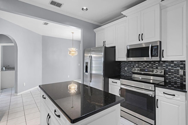 1802 Imperial Palm Dr, Apopka, FL 32712 - kitchen with appliances with stainless steel finishes, arched walkways, white cabinetry, tasteful backsplash, and ornamental molding