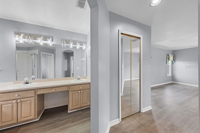 1802 Imperial Palm Dr, Apopka, FL 32712 - bathroom featuring a stall shower, wood finished floors, double vanity, a textured ceiling, and baseboards