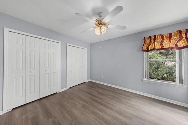 1802 Imperial Palm Dr, Apopka, FL 32712 - unfurnished bedroom featuring baseboards, multiple closets, dark wood-style floors, and ceiling fan