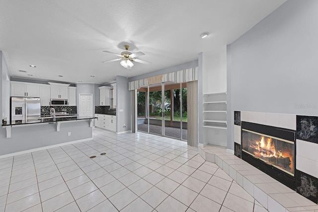 1802 Imperial Palm Dr, Apopka, FL 32712 - unfurnished living room with a fireplace, a ceiling fan, light tile patterned flooring, a sink, and baseboards