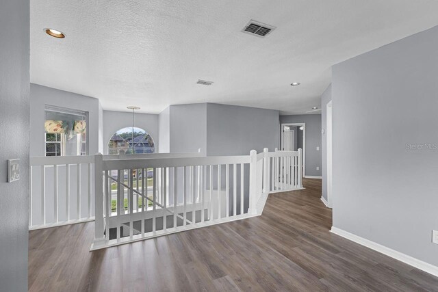 1802 Imperial Palm Dr, Apopka, FL 32712 - hall with baseboards, wood finished floors, a textured ceiling, an upstairs landing, and recessed lighting