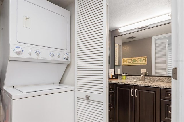 3221 White Ibis Ct Unit C1, Punta Gorda, FL 33950 - laundry room featuring stacked washer / dryer and a textured ceiling