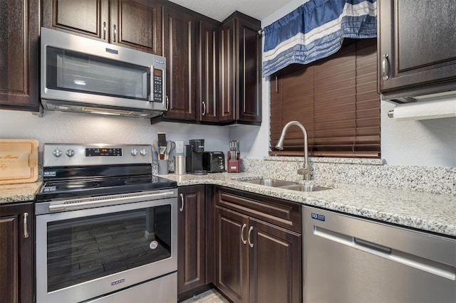 3221 White Ibis Ct Unit C1, Punta Gorda, FL 33950 - kitchen featuring stainless steel appliances, a sink, dark brown cabinetry, and light stone counters