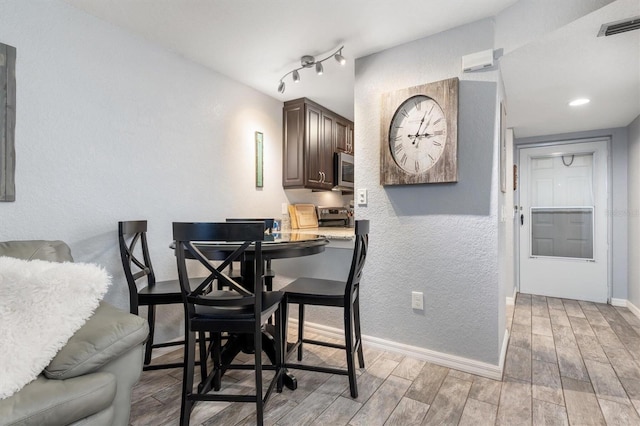 3221 White Ibis Ct Unit C1, Punta Gorda, FL 33950 - dining room featuring light wood finished floors, baseboards, and a textured wall