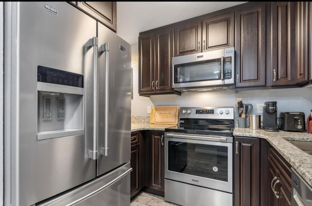 3221 White Ibis Ct Unit C1, Punta Gorda, FL 33950 - kitchen with stainless steel appliances, dark brown cabinets, and light stone counters