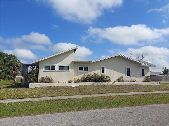 4299 Bullard St, North Port, FL 34287 - view of property exterior with stucco siding and a lawn