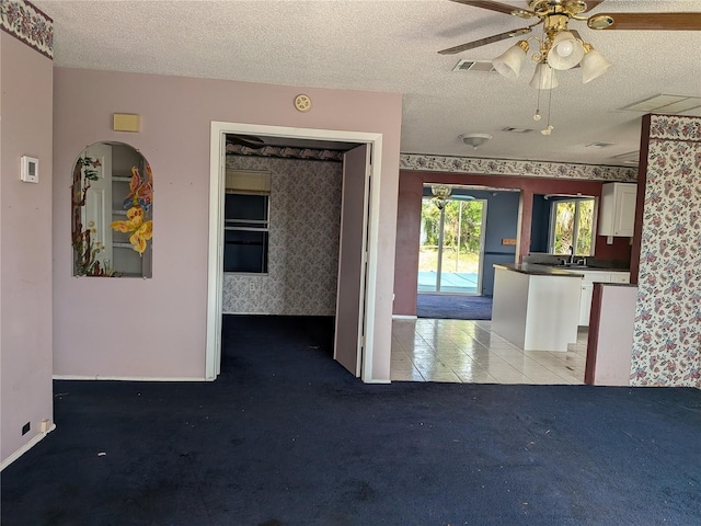 4299 Bullard St, North Port, FL 34287 - carpeted spare room with ceiling fan, a textured ceiling, baseboards, wallpapered walls, and a sink