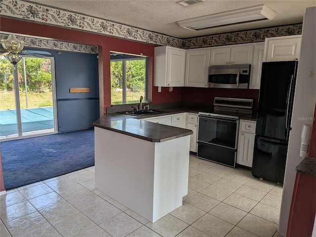 4299 Bullard St, North Port, FL 34287 - kitchen with black appliances, a sink, dark countertops, a peninsula, and light tile patterned floors