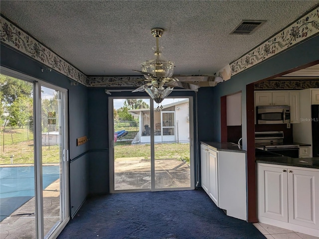 4299 Bullard St, North Port, FL 34287 - unfurnished dining area featuring carpet, a textured ceiling, plenty of natural light, and wallpapered walls