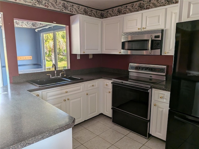 4299 Bullard St, North Port, FL 34287 - kitchen with stainless steel microwave, freestanding refrigerator, electric range, a sink, and white cabinetry